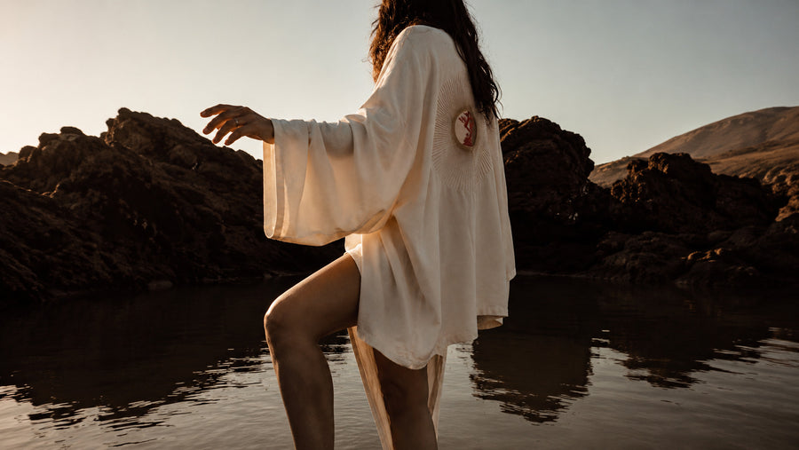 Woman running through Hawaii valley in LVX kimono at sunset