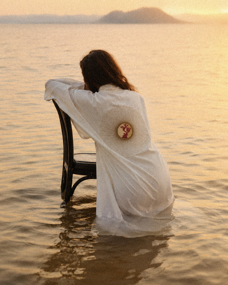 Woman seated on a chair in the lake wearing an LVX kimono